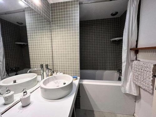 une salle de bain avec deux lavabos et une baignoire et une baignoire dans l'établissement Résidence Les Pins Tranquilles - Arcachon Ville d’Hiver – Charmant T3 avec Terrasse Privée MAE-9514, à Arcachon
