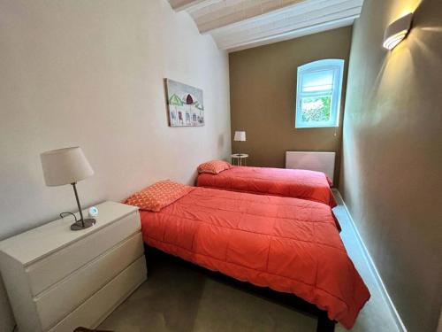 - 2 lits dans une petite chambre avec des draps rouges dans l'établissement Résidence Les Pins Tranquilles - Arcachon Ville d’Hiver – Charmant T3 avec Terrasse Privée MAE-9514, à Arcachon