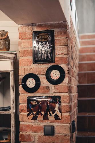 a brick wall with records and pictures on it at Penzion Hádlík in Velké Pavlovice