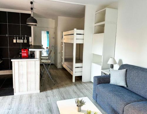 Il comprend un salon doté d'un canapé et une cuisine équipée de lits superposés. dans l'établissement Résidence Arguin 2 - Studio à Arcachon, emplacement idéal MAE-9564, à Arcachon