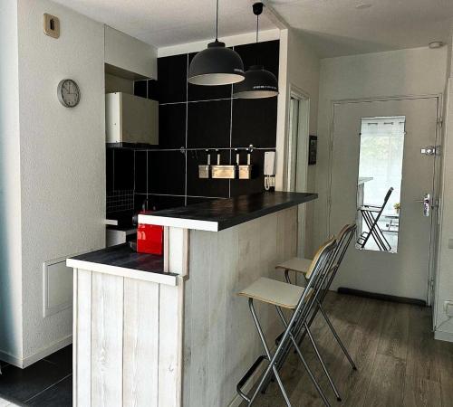 - une cuisine avec un comptoir et des chaises dans la chambre dans l'établissement Résidence Arguin 2 - Studio à Arcachon, emplacement idéal MAE-9564, à Arcachon