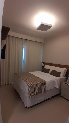a bedroom with a large bed and a light on the ceiling at Pousada Boutique do lazer in Cabo Frio