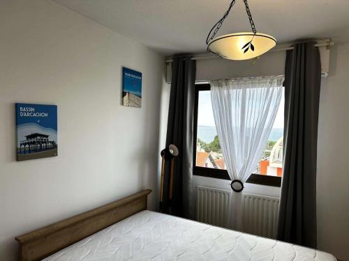 une chambre avec un lit et une grande fenêtre dans l'établissement Résidence Sun Beach - Appartement vue mer avec 2 balcons, proche plage MAE-9694, à Arcachon