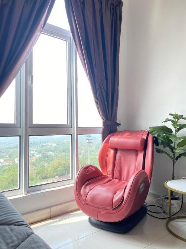 a red chair sitting in a room with windows at Mesahill Studio King With Massage Chair Above Shopping Mall, Cinema & Bowling, 5 Minutes to USIM, Nilai - 24H Self and Easy Check In in Nilai