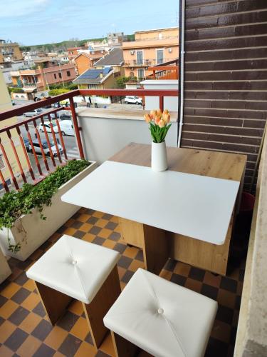 a white table and two stools on a balcony at La casa di Fred in Rome