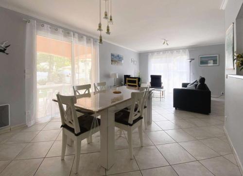 une salle à manger et un salon avec une table et des chaises dans l'établissement Résidence 442-arcachon - Agréable Maison de plain-pied de 100 m² MAE-7694, à Arcachon