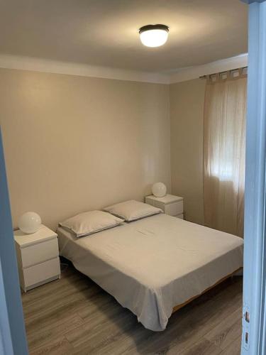 - une chambre avec un lit blanc et 2 tables de chevet dans l'établissement le meublé du pêcheur 2, à Port-Saint-Louis-du-Rhône