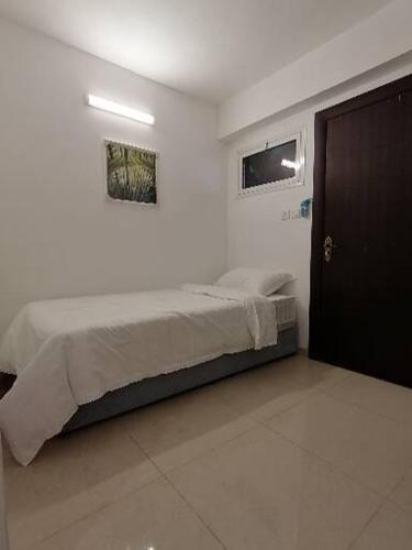 a bedroom with a bed in a white room at Rayan Residence in Jeddah