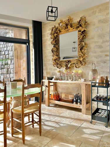 - un salon avec une table et un miroir dans l'établissement Le Paradis de Lucile, 2 chambres dans maison de charme, Giverny 10 mn, à La Roche-Guyon