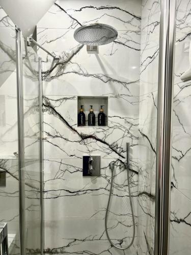 La salle de bains est pourvue d'une douche et de 3 bouteilles de vin. dans l'établissement Le Paradis de Lucile, 2 chambres dans maison de charme, Giverny 10 mn, à La Roche-Guyon