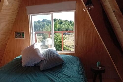 a bed in a room with a window at Casa Alpina Puerto Varas in Puerto Varas