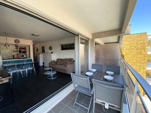 un salon avec une table et des chaises sur un balcon dans l'établissement Résidence Joigny - T2 avec Vue Latérale sur la Mer MAE-9811, à Arcachon