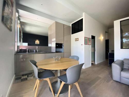 une cuisine et une salle à manger avec une table et des chaises en bois dans l'établissement Résidence Royal Moulleau - T2 de standing à Le Royal Moulleau, vue Bassin MAE-9841, à Arcachon