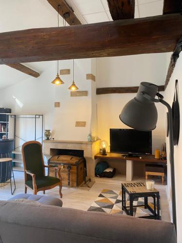 a living room with a couch and a table and a lamp at Le Nid Paisible in Verdun