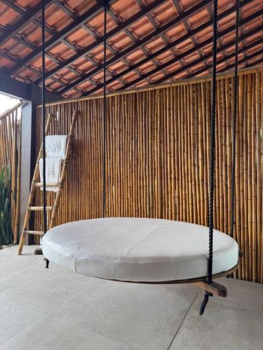 a swinging bed in a room with a wooden wall at Casa da Ilha in Praia de Araçatiba