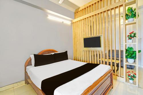 a bedroom with a white and black bed and a tv at Hotel O Sahasra Residency Near Nexus Hyderabad in Hyderabad