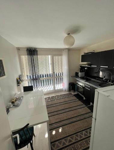 - une cuisine avec une table blanche et un comptoir dans l'établissement Le petit cocon, à Grenoble