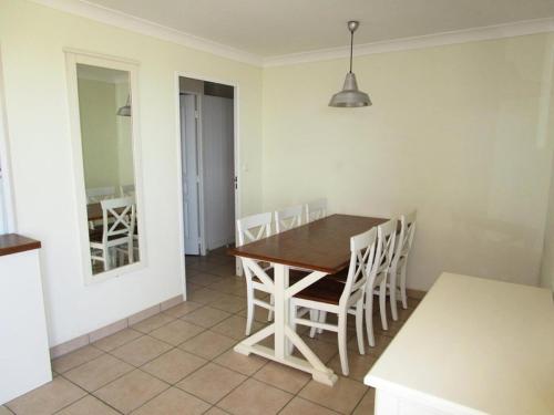 une cuisine et une salle à manger avec une table et des chaises en bois dans l'établissement Résidence Bleu Marine - Appartement 6 pers, vue mer, résidence Bleu Marine avec piscine à Lacanau océan MAE-0301, à Lacanau