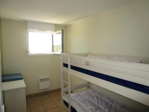 une chambre avec deux lits superposés et une fenêtre dans l'établissement Résidence Bleu Marine - Appartement 6 pers, vue mer, résidence Bleu Marine avec piscine à Lacanau océan MAE-0301, à Lacanau