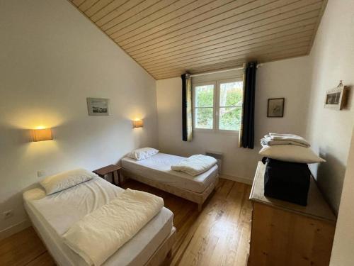 une chambre avec deux lits et une fenêtre dans l'établissement Résidence Vitanova - Maison spacieuse 8 personnes proche golf et pistes cyclables à Lacanau Océan MAE-0391, à Lacanau