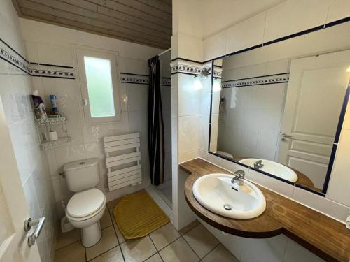une salle de bain avec un lavabo, des toilettes et un miroir dans l'établissement Résidence Vitanova - Maison spacieuse 8 personnes proche golf et pistes cyclables à Lacanau Océan MAE-0391, à Lacanau