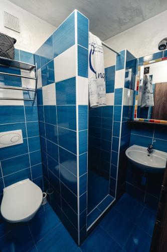 a blue tiled bathroom with a toilet and a sink at Penzion Hádlík in Velké Pavlovice
