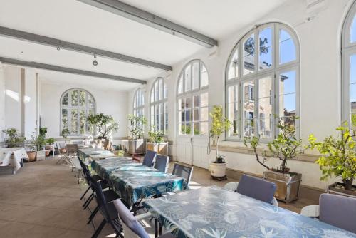 Cette chambre comprend des tables, des chaises et des fenêtres. dans l'établissement Domaine Séquoia, à Buellas