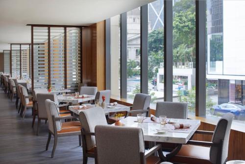 a dining room with tables and chairs and windows at Mandarin Oriental, Hong Kong in Hong Kong