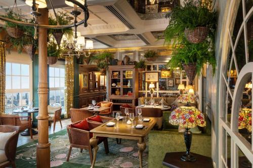 un ristorante con tavoli, sedie e piante di Mandarin Oriental, Hong Kong a Hong Kong
