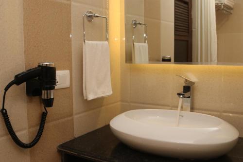 uma casa de banho com um lavatório branco e um espelho. em Hotel Harmika em Kathmandu