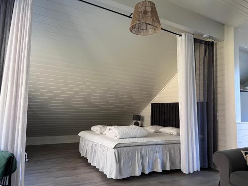 a bedroom with a bed with white sheets at Medvik Högalid in Strömstad