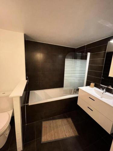 une salle de bain avec une baignoire, des toilettes et un lavabo dans l'établissement Résidence Maisons De L Ocean - Charmant appartement 4 personnes, belle vue Mer MAE-0571, à Lacanau