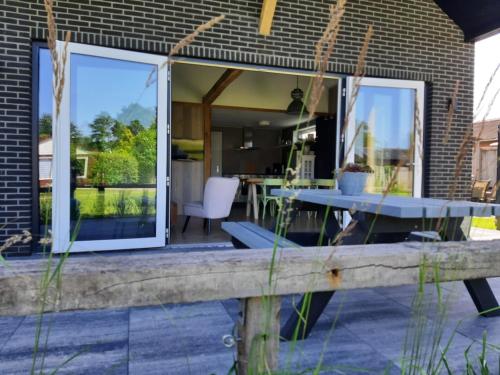 a patio with a table and a dining room at 2 huizen naast elkaar honden welkom omheinde tuin sauna buitenbad 10 personen in Dirkshorn
