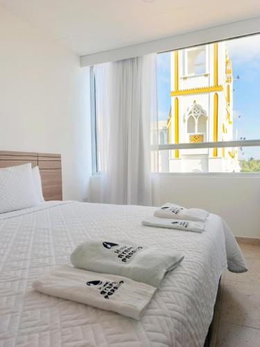 a bedroom with a white bed with a large window at Hotel Ayapel Paraiso in Ayapel