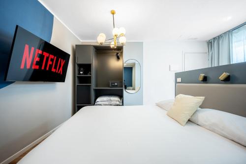 a bedroom with a large white bed and a tv at - NumberZ - Rooms Apartments and Suites with Wi-Fi and AC in Borgo Isonzo