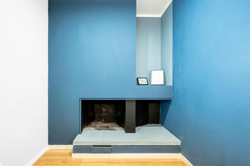 a room with a blue wall and a fireplace at - NumberZ - Rooms Apartments and Suites with Wi-Fi and AC in Borgo Isonzo