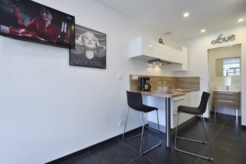 une cuisine avec une table et des chaises dans une pièce dans l'établissement Studio POPPY - Port Nature 461 - Luxe - 2 personnes, au Cap d'Agde