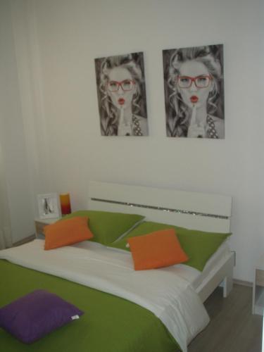 a bedroom with a bed with orange and green at Barko apartment and rooms in Hvar