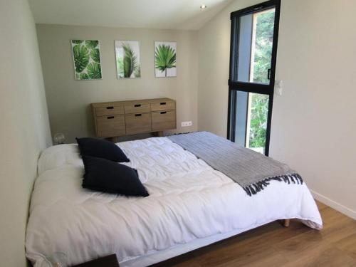une chambre avec un grand lit et une fenêtre dans l'établissement Résidence Margalex - Maison mitoyenne dans belle résidence neuve, piscine collective à Lacanau Océan MAE-0681, à Lacanau
