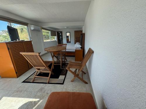 a room with chairs and a table and a bedroom at VILLA COSTERA HOTEL BOUTIQUE in Acapulco