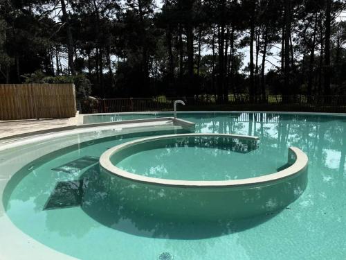 d'une piscine d'eau avec un bain à remous. dans l'établissement Résidence Lacanau Les Pins - 01416_ Appartement T2 avec balcon dans résidence avec piscine collective chauffée MAE-0841, à Lacanau