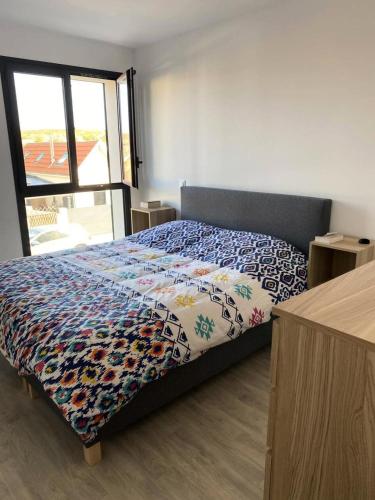 une chambre avec un lit avec une couette colorée dans l'établissement Résidence Roof Top - Appartement T3 neuf pour l'accueil de 6 personnes à 70m des plages MAE-0851, à Lacanau