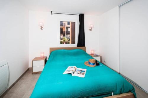 - une chambre avec un lit vert et 2 magazines dans l'établissement Résidence Maisons De L Ocean - Charmant appartement 4 personnes en rez-de-chaussée, petite vue Mer MAE-0761, à Lacanau
