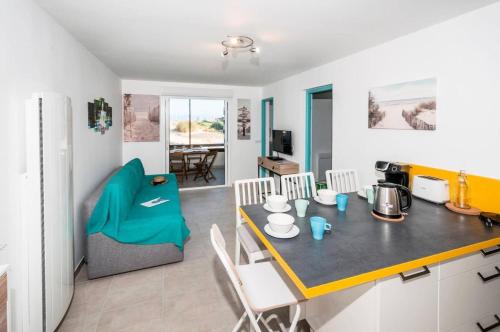 une cuisine et un salon avec une table et des chaises dans l'établissement Résidence Maisons De L Ocean - Charmant appartement 4 personnes en rez-de-chaussée, petite vue Mer MAE-0761, à Lacanau