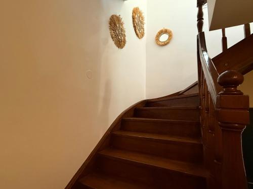 a staircase with wooden steps and two wreaths on the wall at La Vista Residence - 5 BDS, 2 private swimming pools, stunning sea views only 10 minutes from Corfu Town's Centre in Gouvia