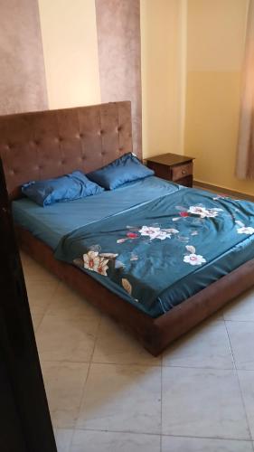 a bed with a blue blanket on top of it at Saidia appartments in Saïdia