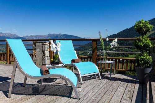 une paire de chaises et une table sur une terrasse dans l'établissement CGH Résidence Boutique La Grange aux fées, à Valmorel