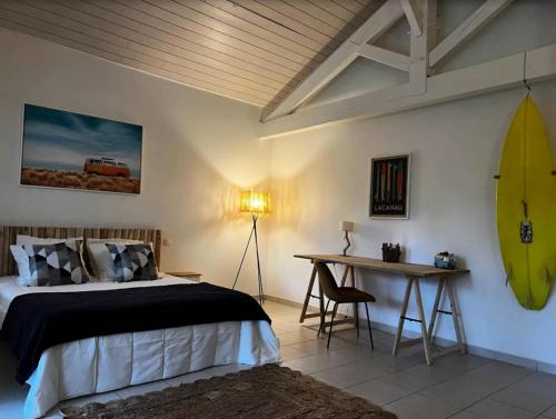 - une chambre avec un lit et une planche de surf sur le mur dans l'établissement Résidence Atlantic Green - Villa spacieuse avec piscine chauffée pour 10 personnes Lacanau Océan MAE-0951, à Lacanau