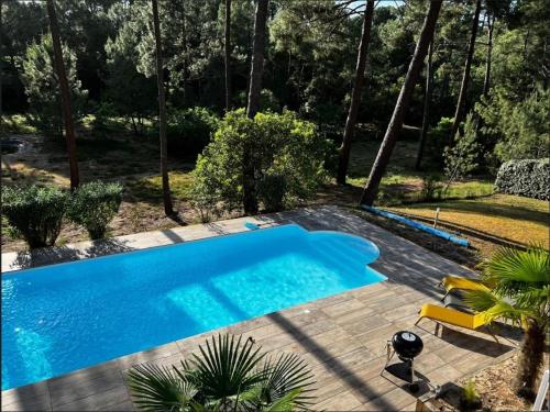 une image d'une piscine dans une cour dans l'établissement Résidence Atlantic Green - Villa spacieuse avec piscine chauffée pour 10 personnes Lacanau Océan MAE-0951, à Lacanau