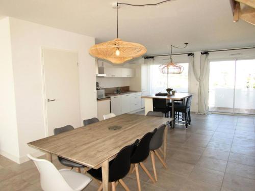 une cuisine et une salle à manger avec une table et des chaises en bois dans l'établissement Résidence Giralda - Rare - Appartement en front de mer pour 10 personnes - vue mer, wifi compris MAE-0871, à Lacanau